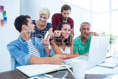 Creative business team using laptop in meeting