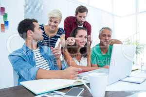 Creative business team using laptop in meeting