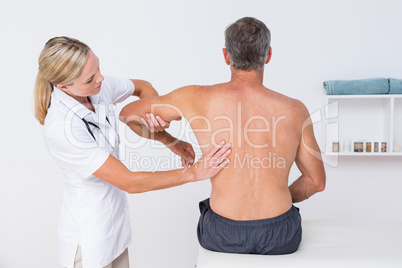 Doctor examining her patient arm