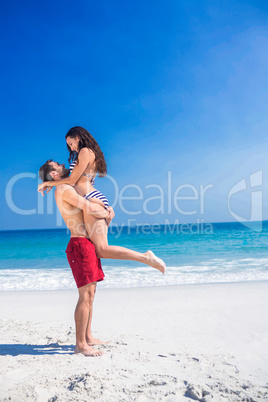 Man lifting his girlfriend at the beach Man lifting his girlfriend at the beach