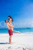 Man lifting his girlfriend at the beach