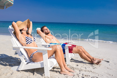 Happy couple relaxing on deck chair at the beach