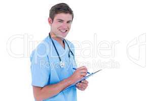 Young nurse in blue tunic writing notes