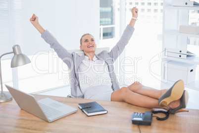 Happy businesswoman with raised arms