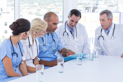 Doctor showing clipboard to his colleagues