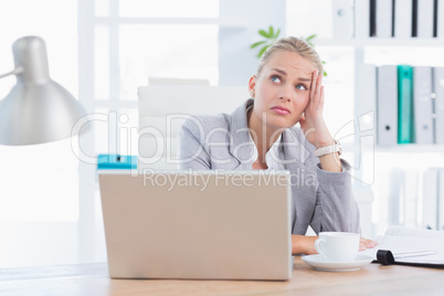 Frustrated businesswoman with head in hand