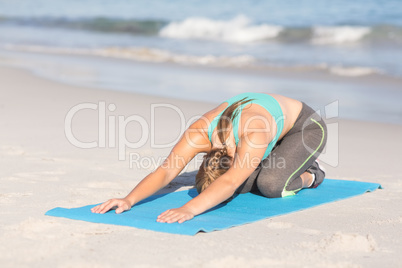 Fit woman stretching her back on exercise mat