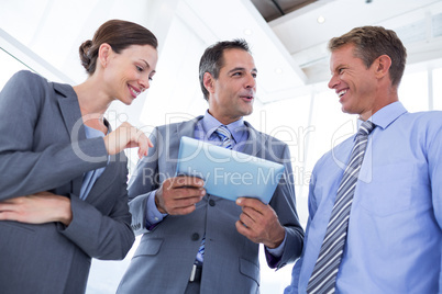 Businessman showing tablet to his colleagues