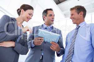 Businessman showing tablet to his colleagues