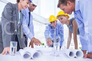 Team of business people looking at construction plan
