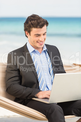 Businessman using laptop on the hammock