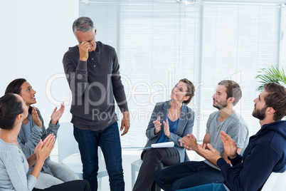 Rehab group applauding delighted man standing up