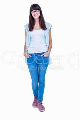 Pretty geeky hipster with hands in pocket smiling at camera