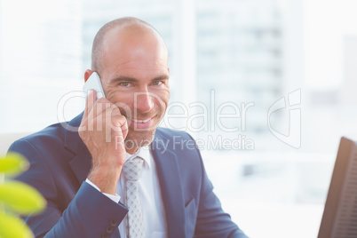 Smiling businessman looking at camera and calling