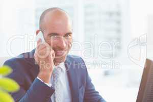 Smiling businessman looking at camera and calling