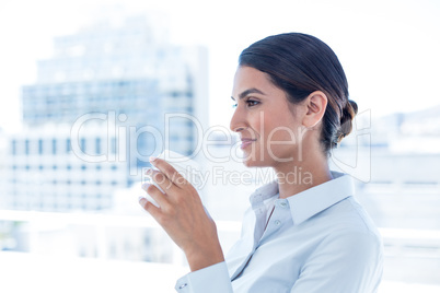 Smiling businesswoman holding disposable cup