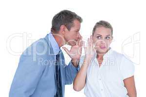 Businessman telling secret to a businesswoman