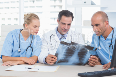 Smiling doctor looking at Xray with his colleagues