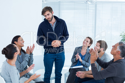 Rehab group applauding delighted man standing up