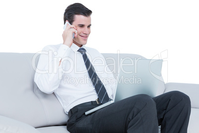 businessman talking on the phone on the sofa with his laptop