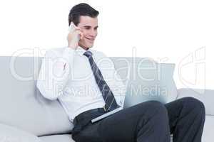 businessman talking on the phone on the sofa with his laptop