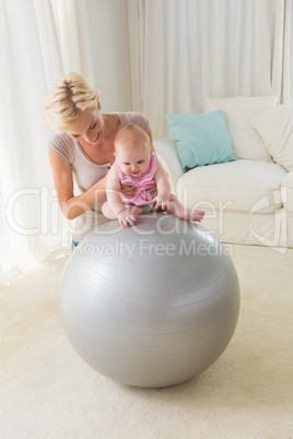 Happy mother with her baby girl on the exercice ball