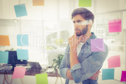 Puzzled businessman looking post its on the wall