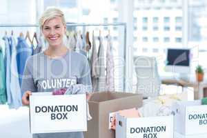 Smiling volunteer holding a box of donations