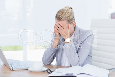 Frowning businesswoman grasping her head