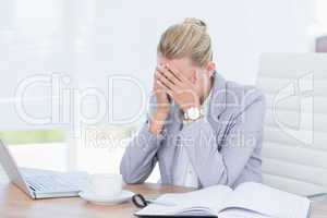 Frowning businesswoman grasping her head