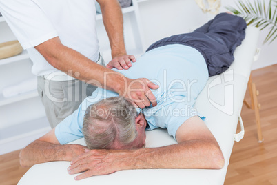 Physiotherapist doing neck massage to his patient