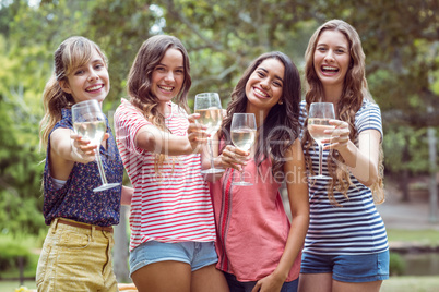 Happy friends drinking in the park