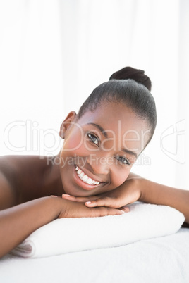 Peaceful pretty woman lying on towel smiling at camera