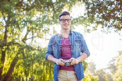 Handsome hipster holding vintage camera