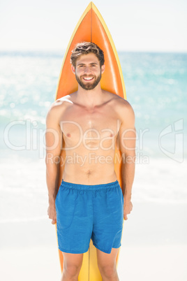 Handsome man holding surfboard