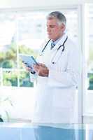 Concentrated doctor holding tablet