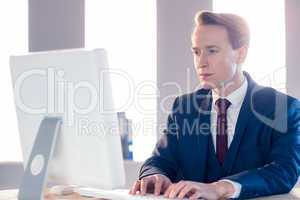 Serious businessman typing on computer