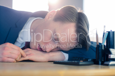 Exhausted businessman sleeping at his desk