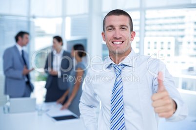 Smiling businessman gesturing thumbs up