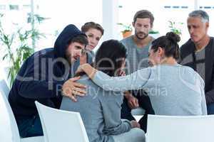 Concerned patients comforting another in rehab group