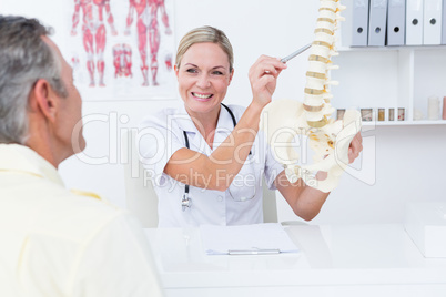 Doctor showing her patient a spine model