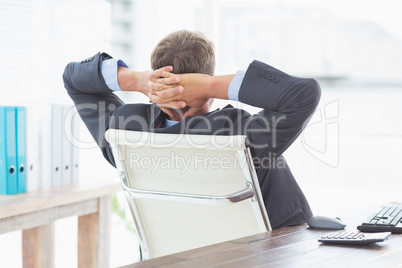 Businessman relaxing in a swivel chair leaning back