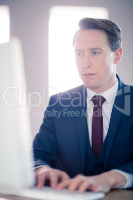 Serious businessman typing on computer