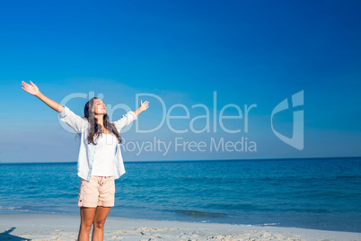 Happy woman with eyes closed at the beach