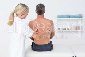 Doctor examining her patient back