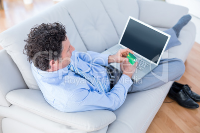 Businessman doing online shopping on couch