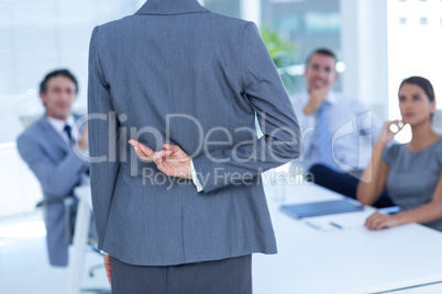 Businesswoman with fingers crossed behind her back