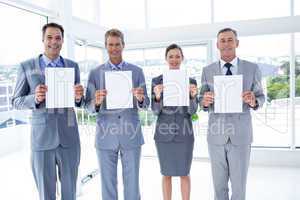 Business colleagues holding sheets of paper together