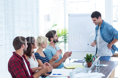 Casual business people clapping hands in meeting