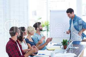 Casual business people clapping hands in meeting